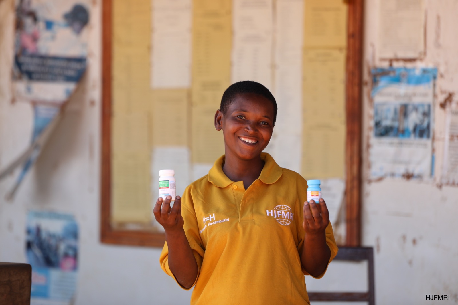 Community member standing with a bicycle in a rural setting